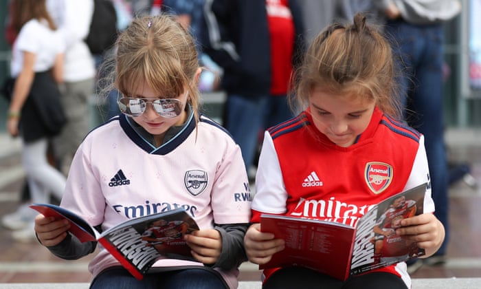 Young fans read the match programme ahead of the Women's Super League match between Arsenal and Tottenham Hotspur.