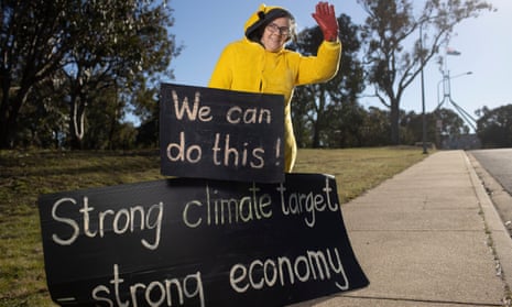 Climate protestor Frances waves to passing traffic at the entrance to Parliament House.