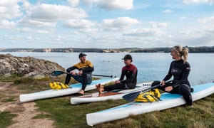Three paddleboarders on shore