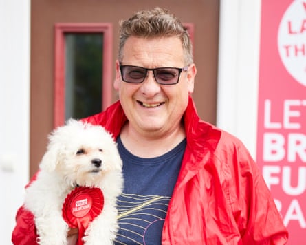 Karl Turner with his white fluffy dog wearing a Labour rosette. 