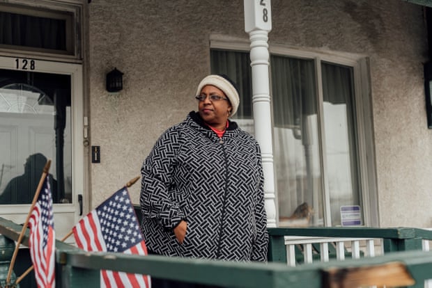 Cathy Morse stands on her porch at her home in Chester, Pennsylvania. Though she would like to move, she can’t because it’s her mother’s home and her mother is elderly and unable to leave.
