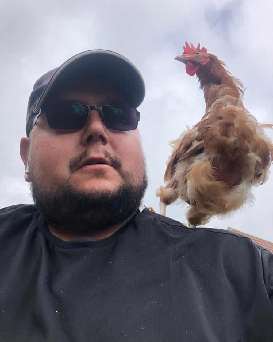 Nicolas, 36 ans, a déclaré que travailler comme coursier signifie faire partie de la communauté.  Il est assis avec un poulet sur son épaule.