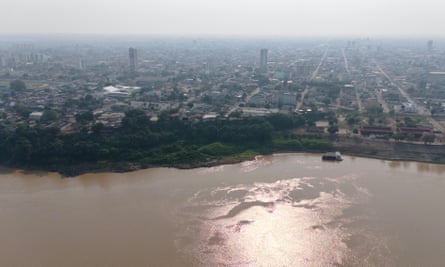 Aerial view of a smoke-covered city on the banks of a river
