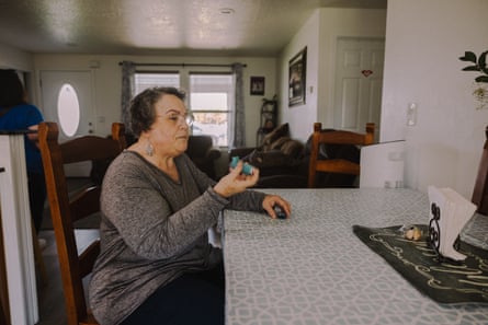 An older woman takes a puff from an inhaler.