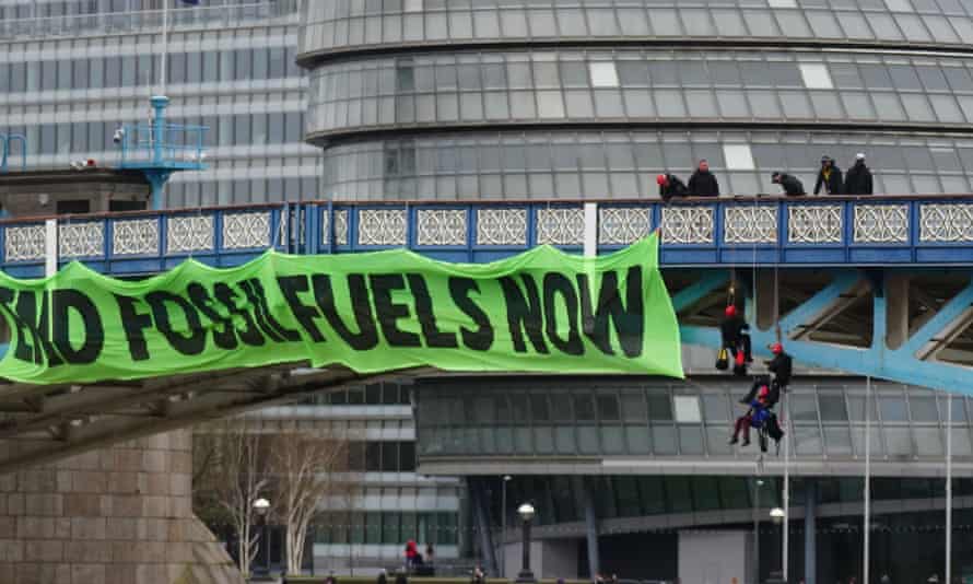 Extinction Rebellion vows fossil fuels protest will ‘grind London to a halt’ | Extinction Rebellion 1 Police officers work to remove Extinction Rebellion activists from Tower Bridge