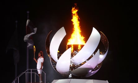 Naomi Osaka of Japan holds the Olympic torch after lighting the cauldron at the opening ceremony.