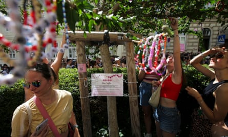 Taylor Swift fans hang beaded necklaces in a park in Vienna