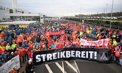 Volkswagen workers march holding a sign with writing reading in German "Ready to Strike!" on the first day of a nationwide warning Volkswagen workers' strike, in Zwickau, Germany, Monday, Dec. 2, 2024. (Hendrik Schmidt/dpa via AP)