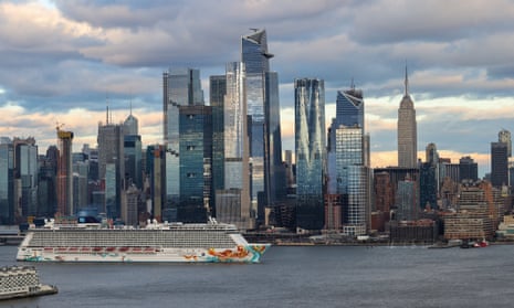 a huge cruise ship passes skyscrapers in New York City