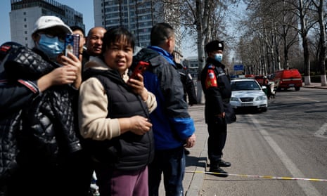 A police officer stands guard behind a security line near the site of a restaurant blast in Hebei