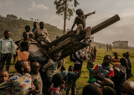 Children displaced by conflict with M23 rebels play on an artillery piece once used by CNDP rebels in the town of Kibumba, North Kivu Province, DRC, 30 January 2022