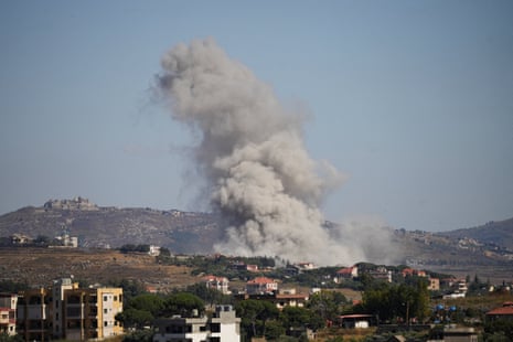Smoke rises above a city from a bombing.