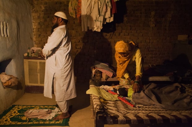 Samsuddil, 41, prays while Najida* puts their three-month-old son to bed in their house in Mewat district on 15 October 2016