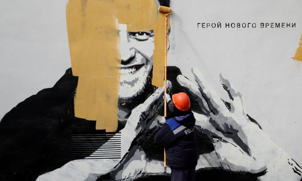 A worker paints over a graffiti depicting Alexei Navalny in Saint Petersburg. Legal aides representing the Navalny movement said they believed the court was attempting to fast-track the hearing.
