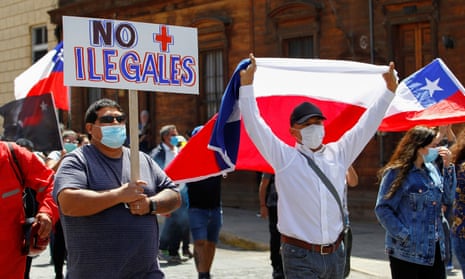 Chilean demonstrators with national flags and a placard that reads ‘No more illegals’ take part in a rally against migrants in Iquique last month.