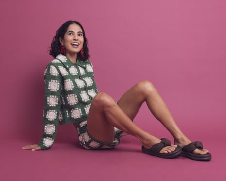 Model in green and white jacket and shorts combo with brown chunky flip-flops on