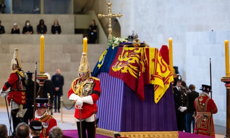 Members of the public walk past the flag-draped coffin of Queen Elizabeth II at Westminster Hall, London.