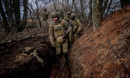 Ukrainian servicemen in a muddy trench near Bakhmut