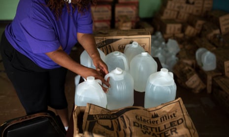 A volunteer prepares gallons of water to be distributed to residents at the Harbor Harvest Urban Ministries in Benton Harbor Michigan.