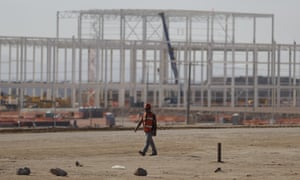 A man walks past the nearly deserted construction site after Ford announced the cancellation of plans to build a $1.6bn plant at San Luis Potosi, Mexico.