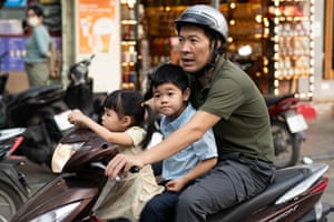 Young children sit at the front and an adult drives a motorbike
