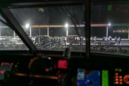 People and vehicles at port side as seen through ferry window