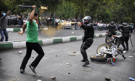 An Iranian riot-police officer sprays teargas at a protester who is attacking him with a police baton, during riots in Tehran in June 2009.
