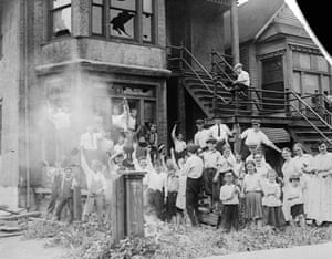 White children cheer outside an African-American residence that they have set on fire. The police arrived soon afterward.