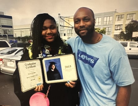 Man in blue T-shirt next to woman holding diploma