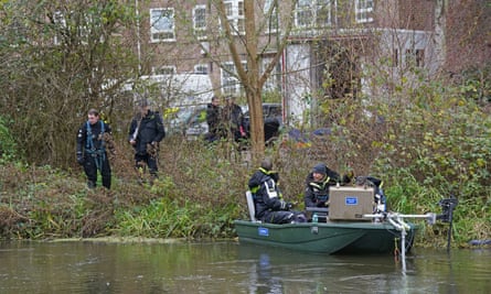 Police by a river and on a boat.