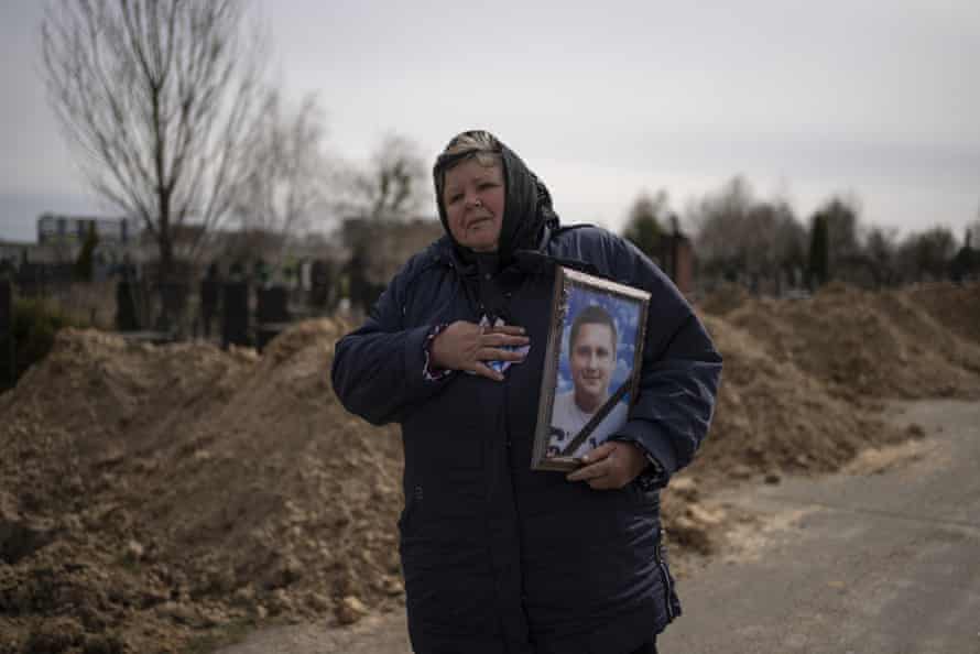 A woman carries the portrait of Dmytro Stefienko, 32, a civilian killed during the war in Bucha, in the outskirts of Kyiv.