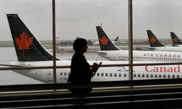 FILE PHOTO: A passenger walks past several Air Canada jets at Vancouver International Airport<br>FILE PHOTO: A passenger walks past several Air Canada jets at Vancouver International Airport, September 26, 2001. REUTERS/Andy Clark/File Photo
