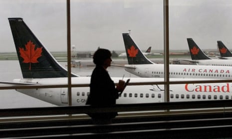 A passenger walks past several Air Canada jets at Vancouver International Airport as Canada announces new border restrictions in response to the new Omicron variant.