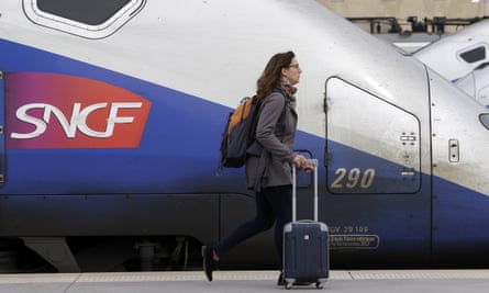 A woman walks past high-speed trains at the Saint Charles station in Marseille