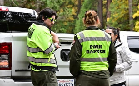 Park rangers standing next to a car
