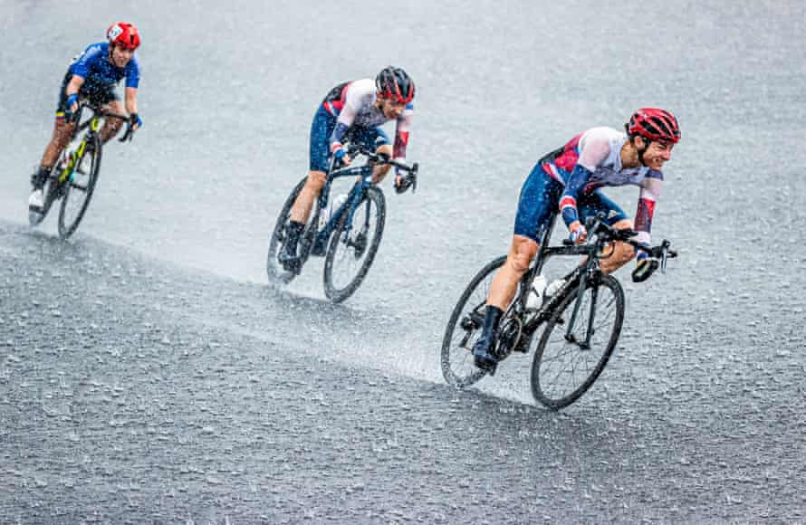 Dame Sarah Storey (right) on her way to winning gold in torrential rain in the road race