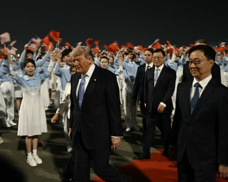Trump walking with Han and others and youths wave Chinese flags in background