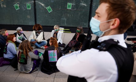 Extinction Rebellion activists wait to be detained outside HSBC in Canary Wharf, London, April 2021.