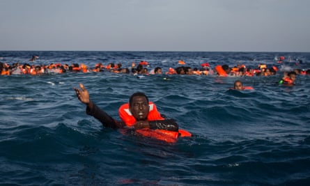 A migrant calls for help after a boat carrying more than 500 people capsized off Lampedusa, Italy, in May 2017.
