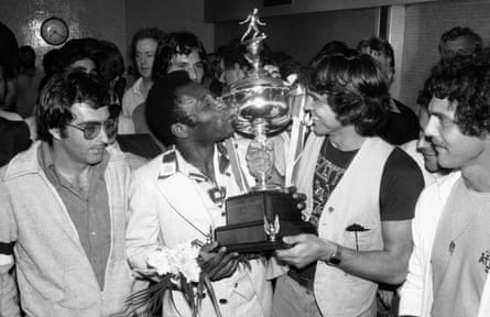 Pelé kisses the trophy held by the New York Cosmos captain Werner Roth at Kennedy airport in August 1977 after winning the North American Soccer League Championship