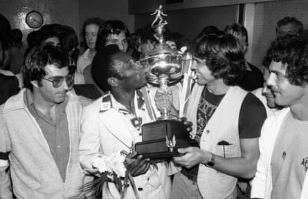 Pelé kisses the trophy held by New York Cosmos captain Werner Ross at Kennedy Airport after winning the North American Soccer League championship in August 1977.