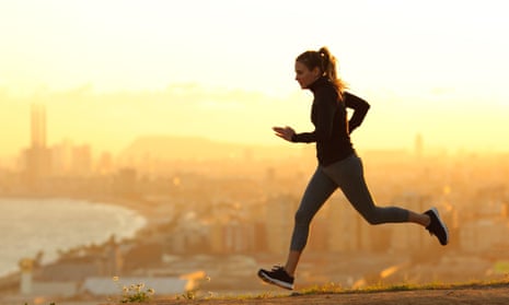 Side view portrait of a woman running in city outskirts at golden sunset