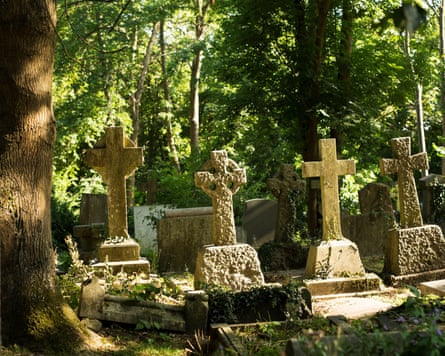 Sunlight shines on the crosses of tombstones at Highgate cemetery, London.