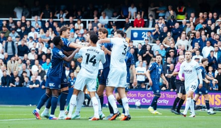 Millwall and West Ham players have a scrap on the pitch.