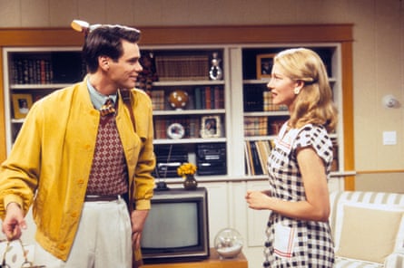 Jim Carrey and Laura Linney wearing 50s-style clothing standing facing each other as if in conversation in a mid-century-style living room, with a TV and bookshelf and sofa seen in the background