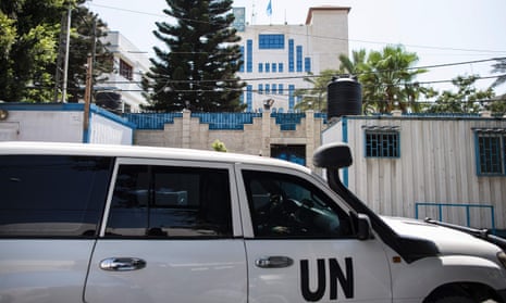 United Nations Development Programme staff drive an official car in front of its headquarters in Gaza