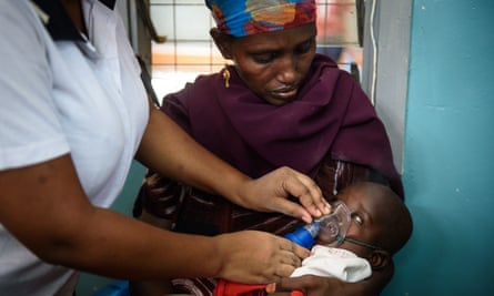 Fatuma Abdi, 38, holds her six-month-old daughter, Sumea Aden, while a nurse uses a nebuliser to ease the child’s rapid breathing in Lodwar, Kenya