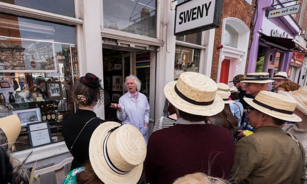 Guide PJ Murphy with a tour group celebrating Bloomsday outside Swenys Pharmacy.