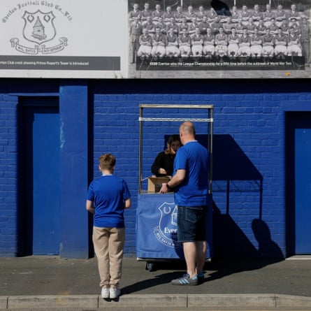 An Everton fan buys a programme on Bullens Road.