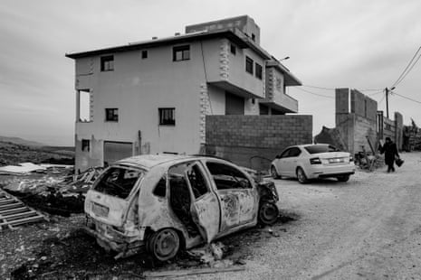 A destroyed car near a house